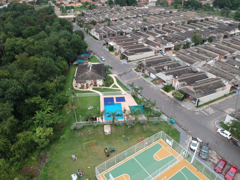 Vista aérea do Condomínio Costa Verde, com casas geminadas, piscina e quadra