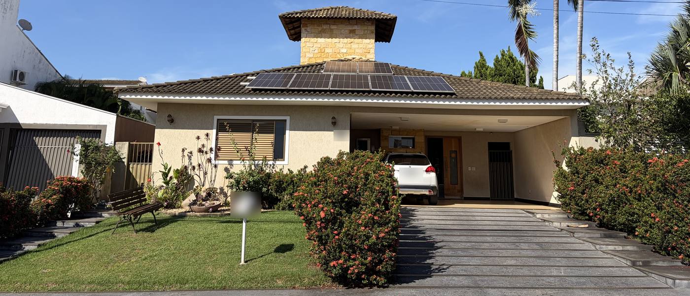 Residência térrea com telhado cerâmico, painéis solares e jardim frontal